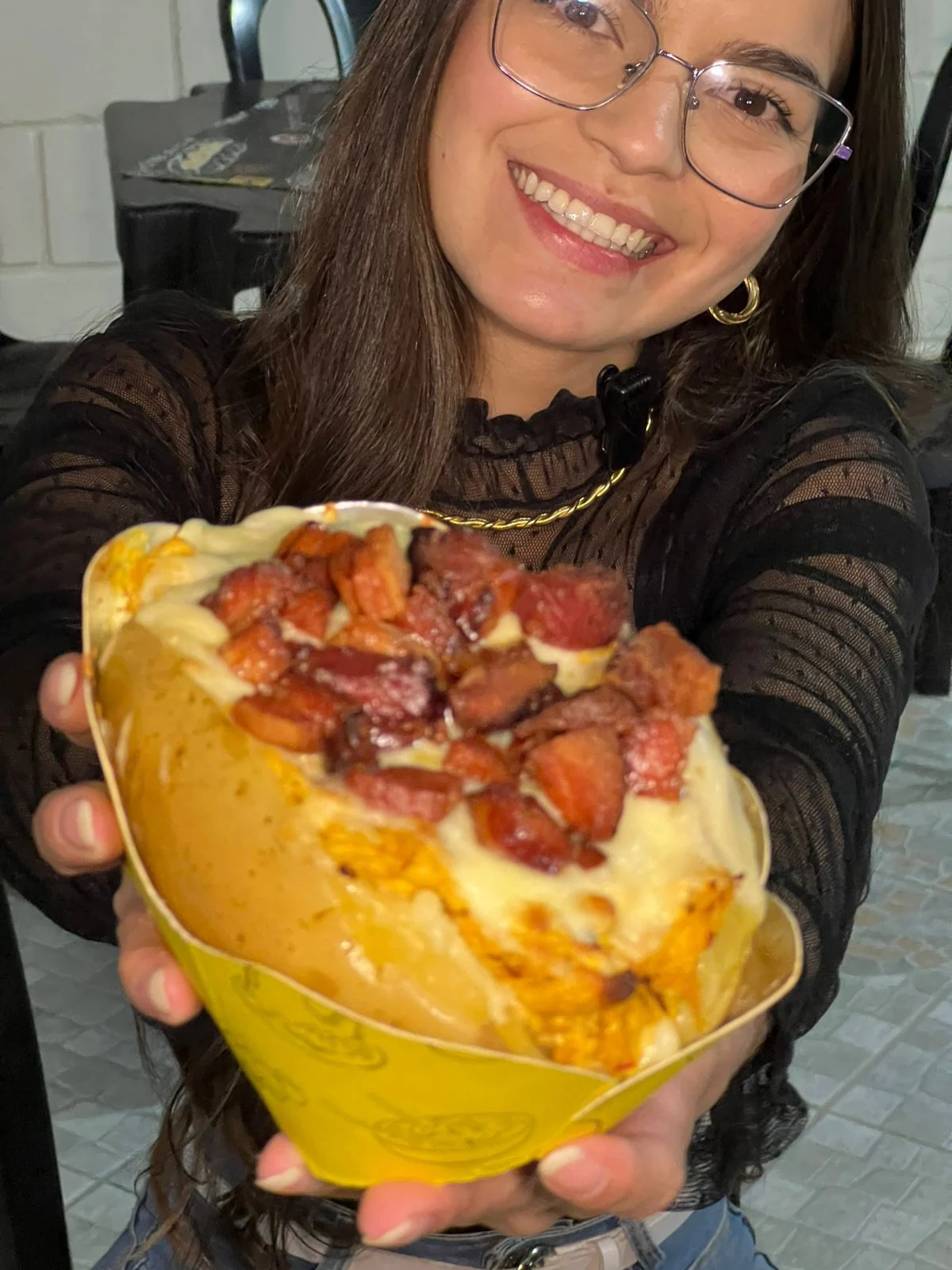 Cliente segurando uma batata recheada Mister Batata